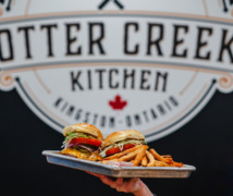 Burgers in front of the Otter Creek Kitchen sign