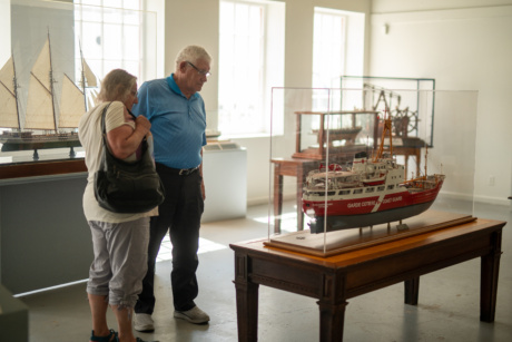People looking at a boat on display