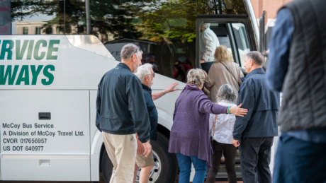 People getting on a tour bus