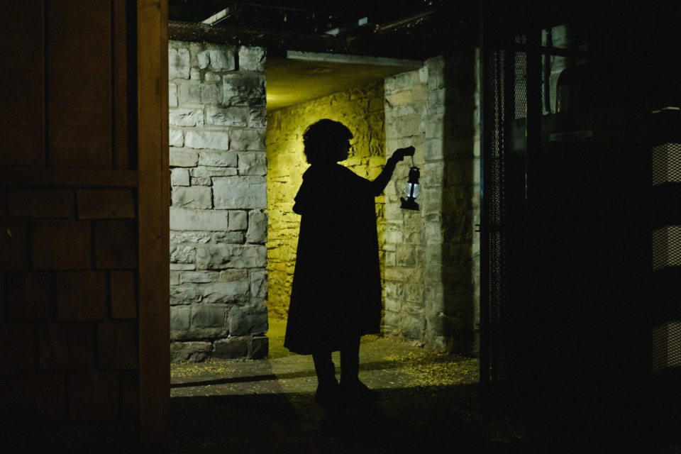 A Haunted Walk of Kingston guide holding a lantern.