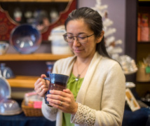 Kaoru holds a mug made by local potter Ikuko Hall. Cha Cha Tea carries a number of pieces by local artisans, as well as tea accessories